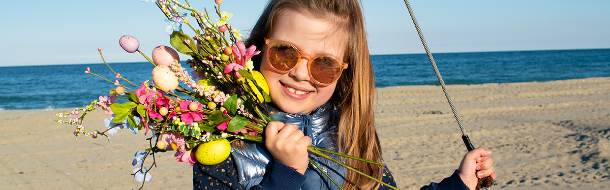 bambina al mare con un mazzo di fiori per pasqua